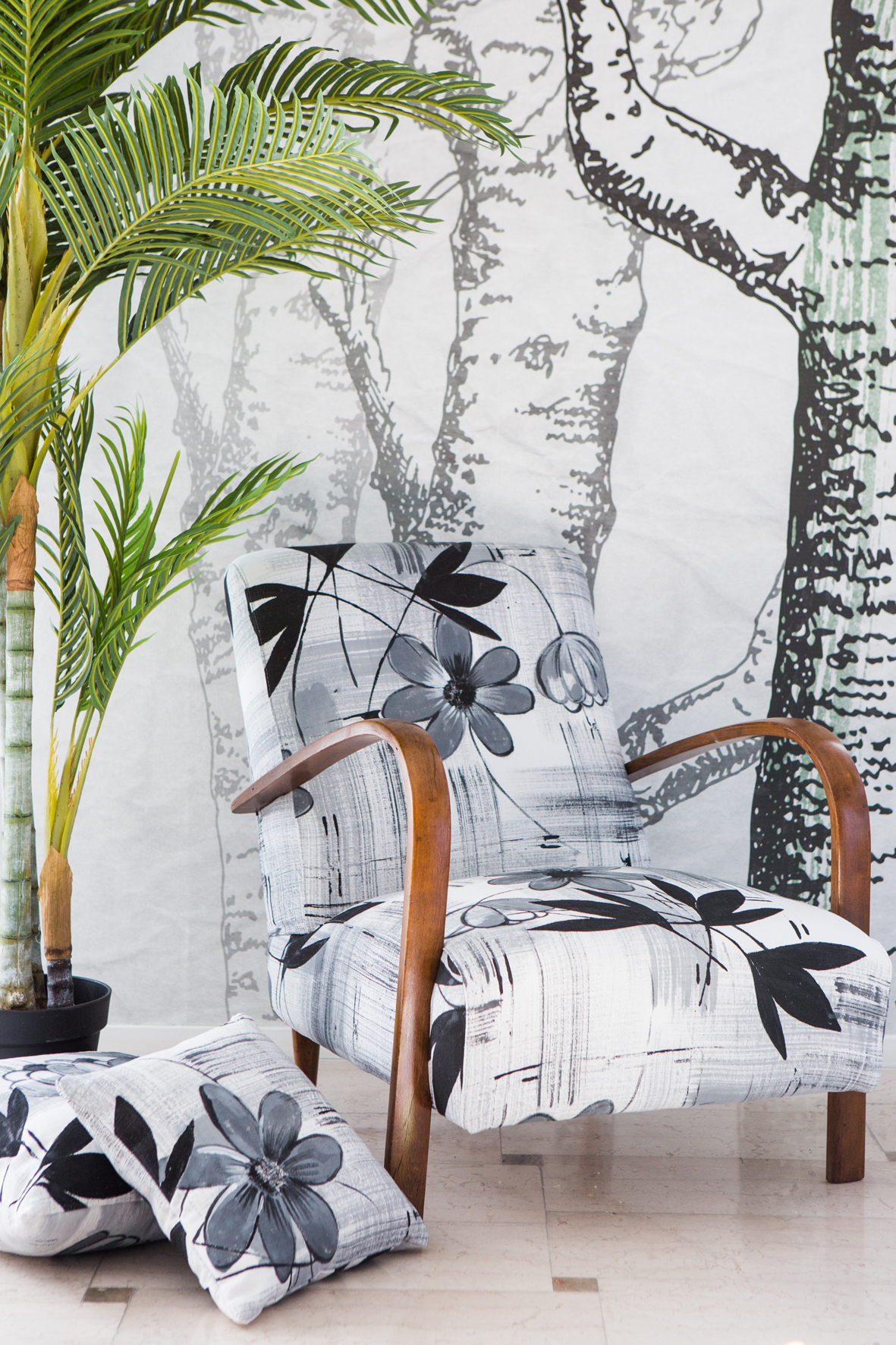 Sedia fatta con tessuto con disegno artistico di fiori bianco e nero con sfondo con alberi disegnati e piante